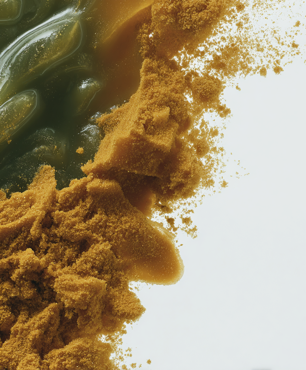 An abstract, close-up image of a pile of brown powder mixing with a dark green, viscous gel.