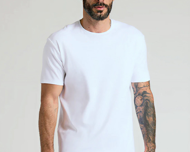 Man wearing a plain white t-shirt with tattooed arm.