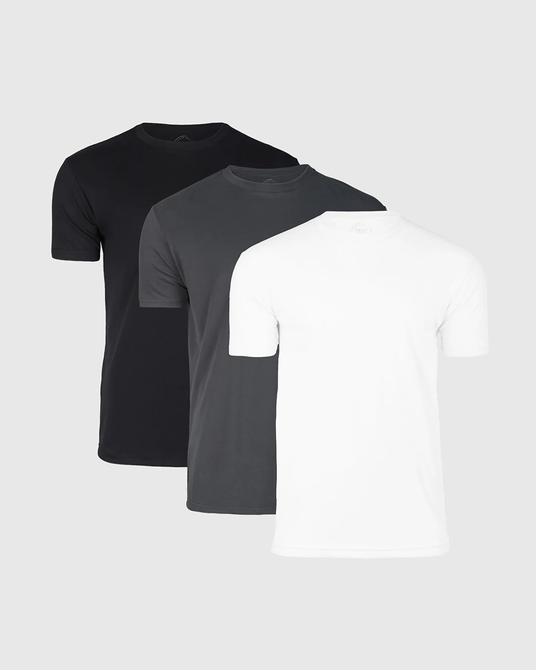 Three stacked plain t-shirts: black, gray, and white.