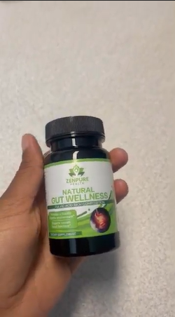 Hand holding a bottle labeled 'ZENPURE Natural Gut Wellness' with a green and white design.