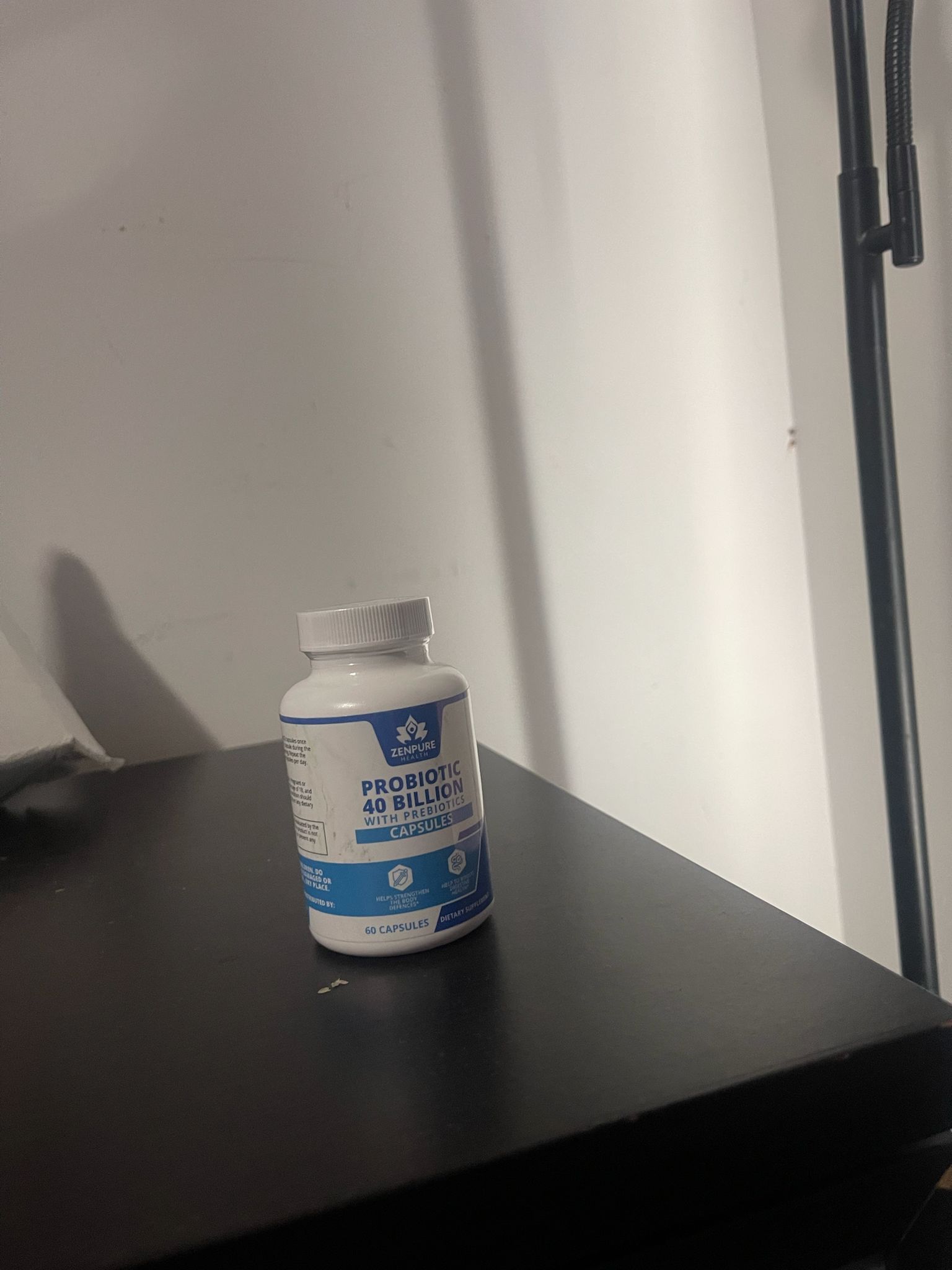 Bottle of probiotic capsules on a dark surface.