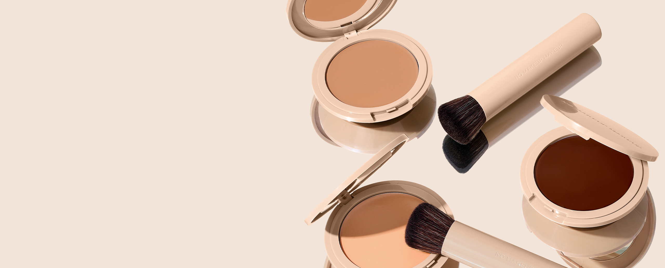 Three makeup compacts and brushes on a beige background.