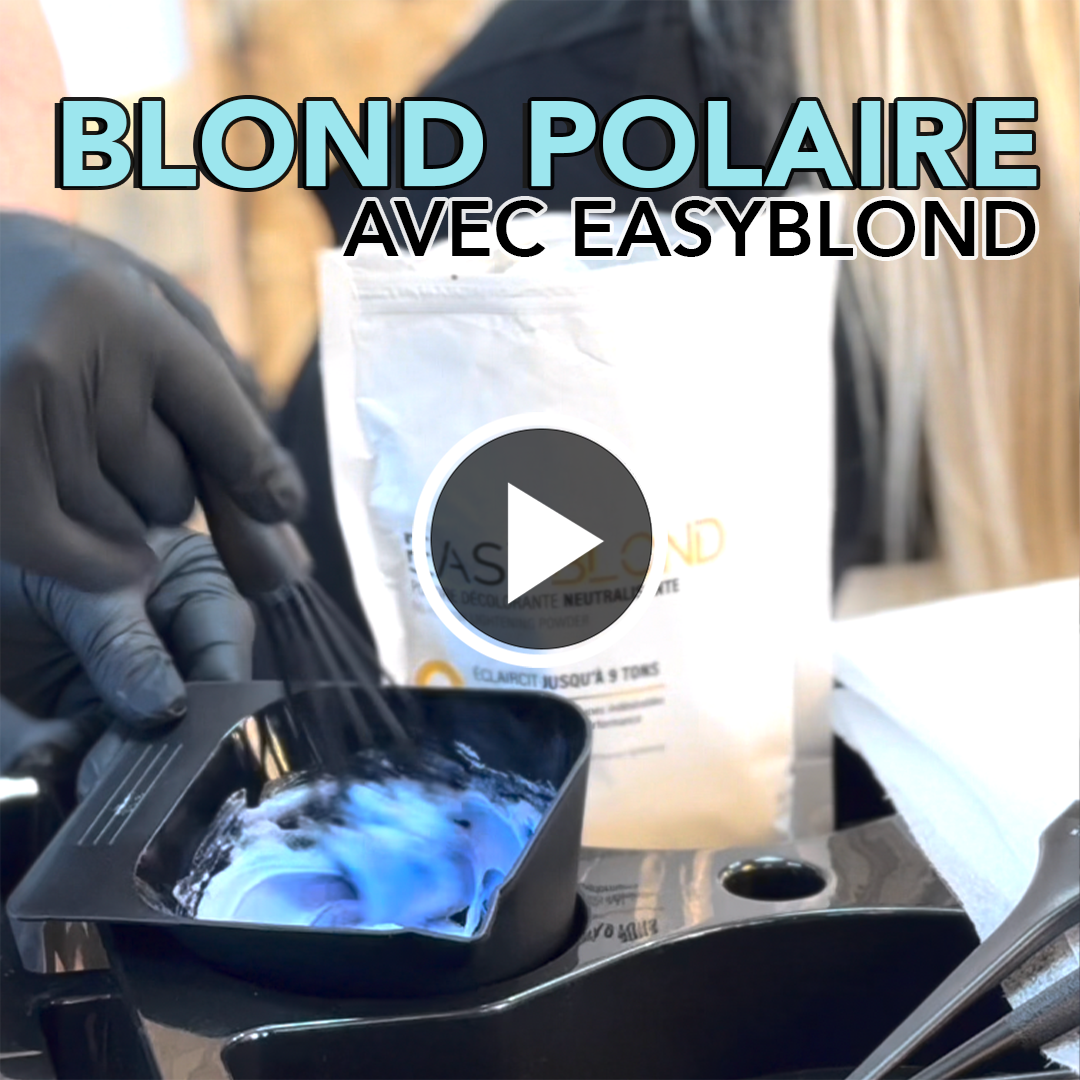 Gloved hand mixing blue hair dye in a black bowl with a whisk.
