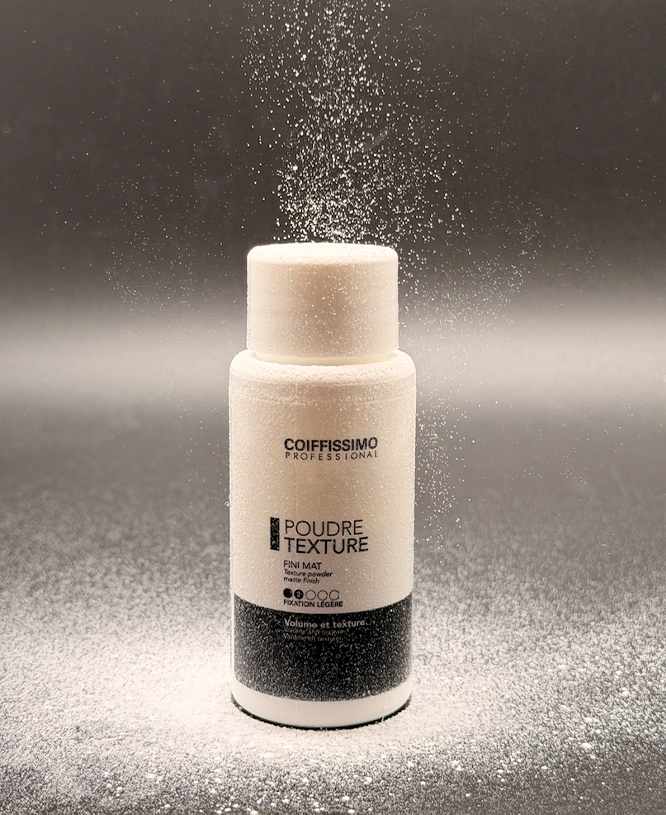 A bottle of Coiffissimo hair texture powder with white powder sprinkling down from above.