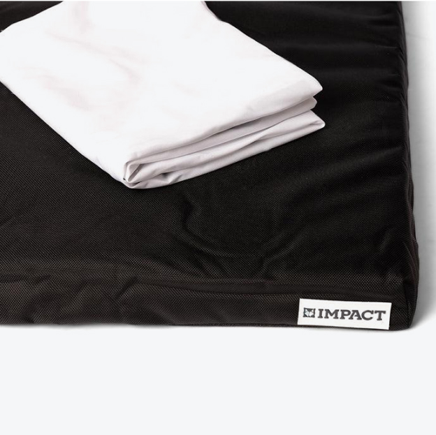 Folded white sheet on a black mat with 'IMPACT' label.