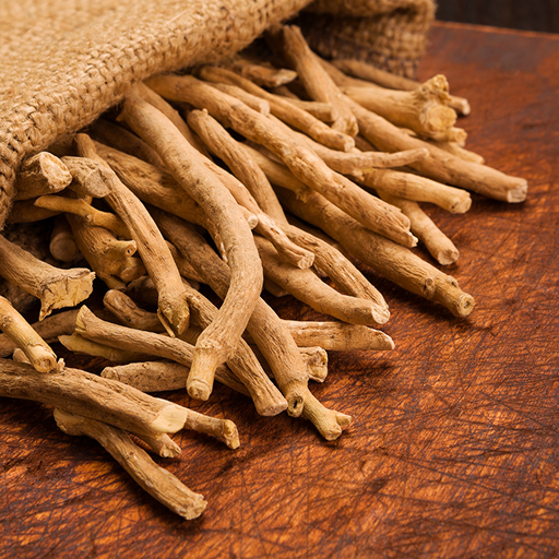 A close-up of dried, light-brown roots spilling out of a burlap sack onto a wooden surface.