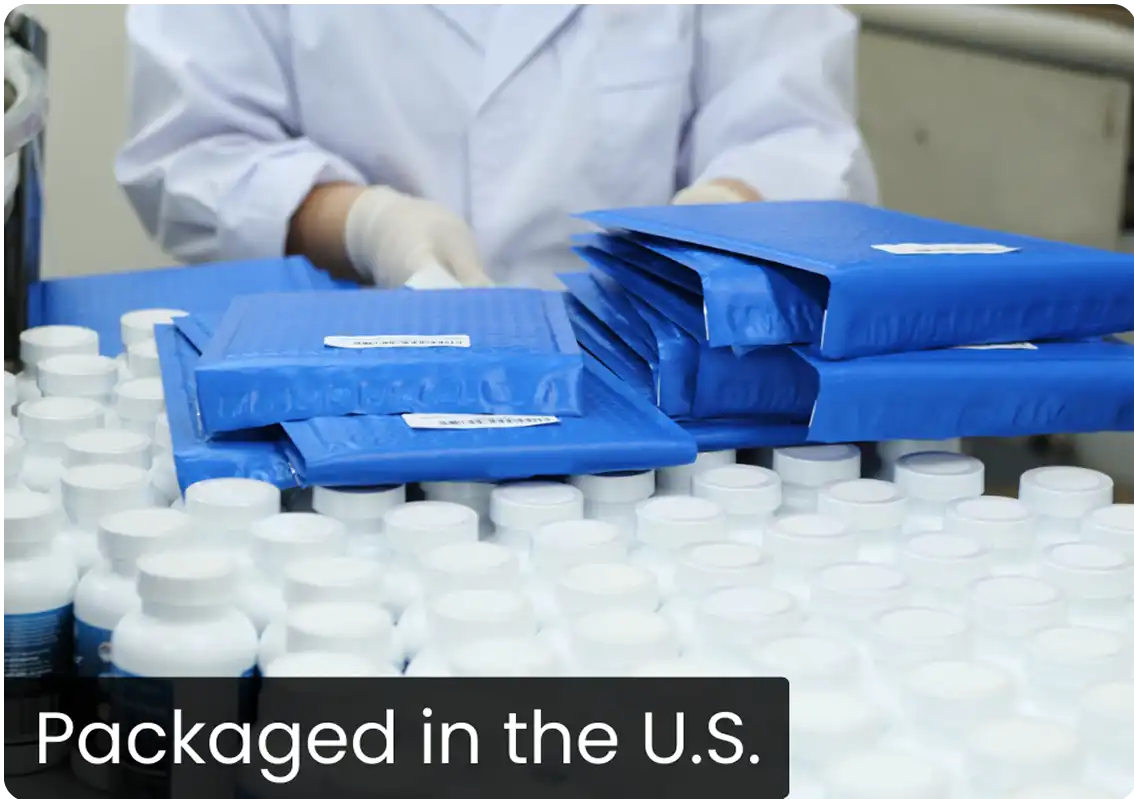 Person handling blue packages and white bottles on a table.