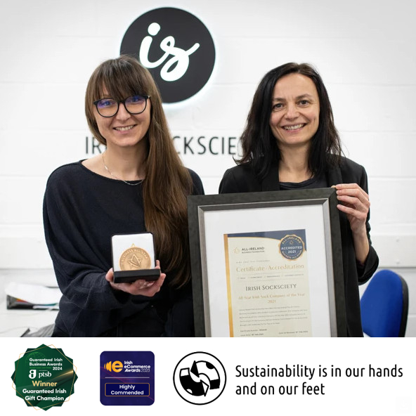 Two people holding an award and certificate, smiling in front of a logo.