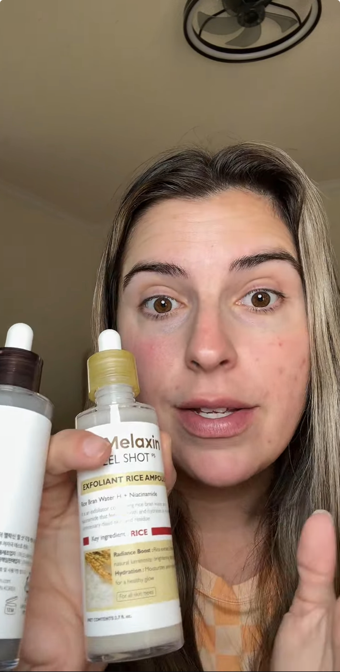 Person holding two skincare bottles, one labeled 'Exfoliant Rice Ampoule.'