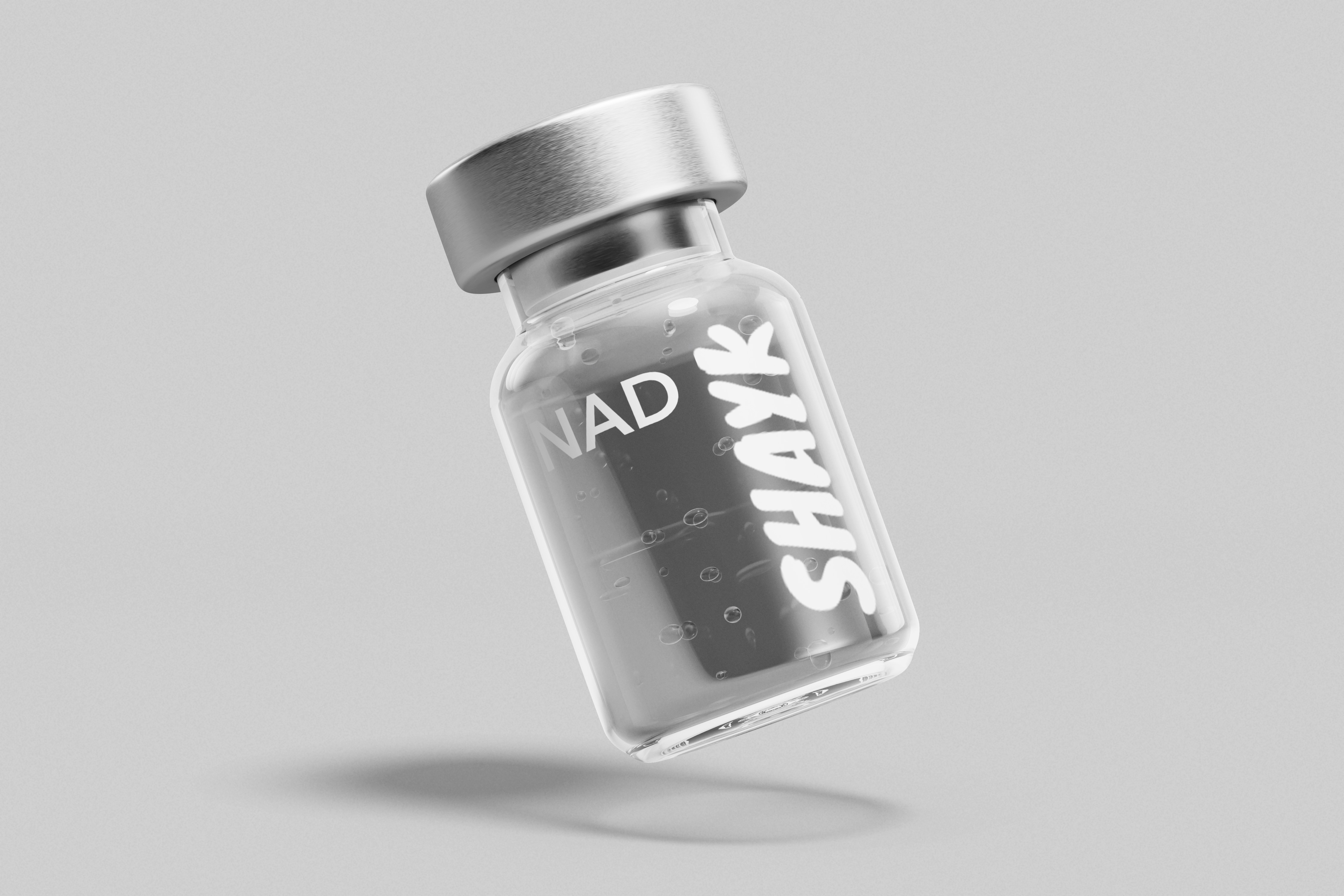 Small glass vial labeled 'NAD SHAYK' with light gray background.