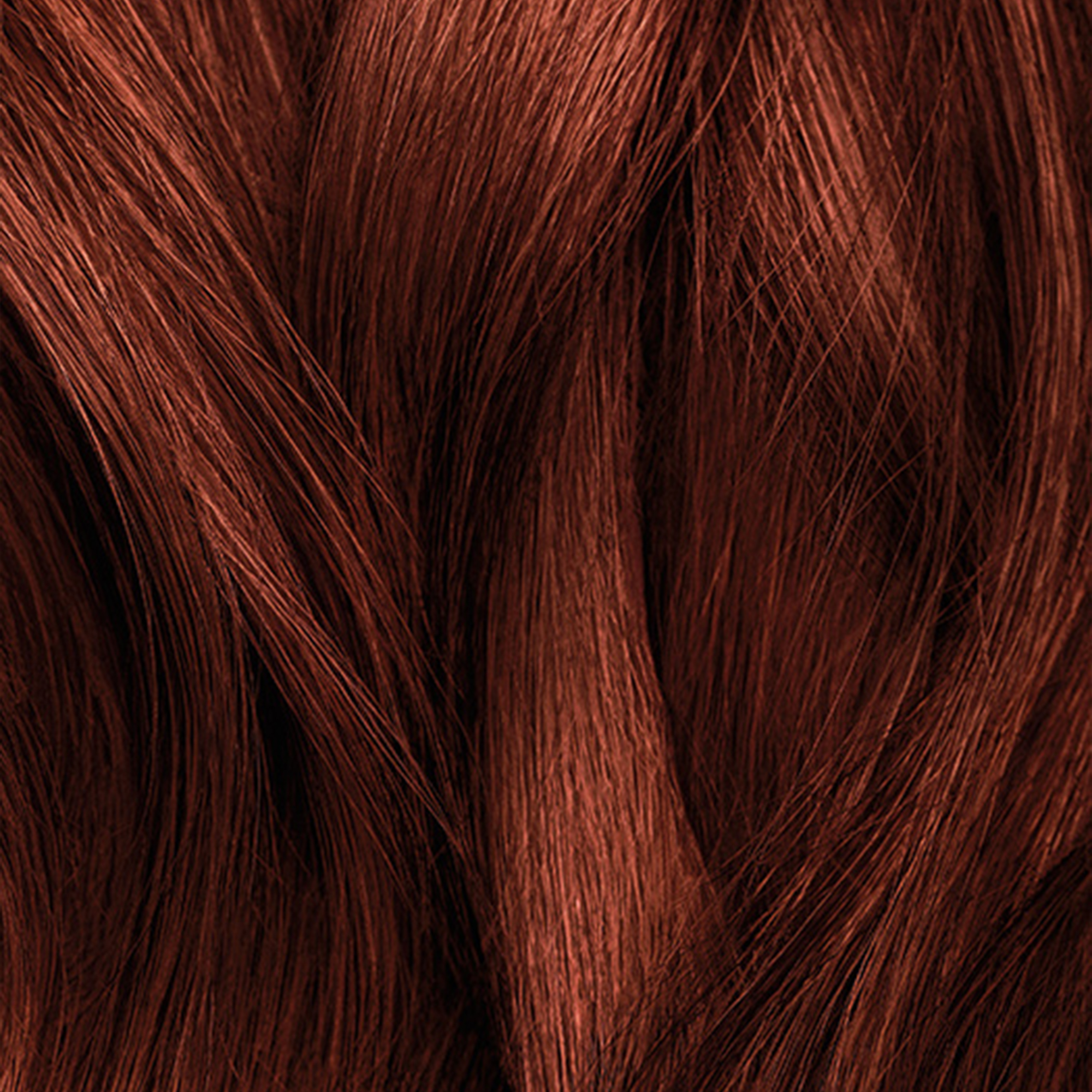 Close-up of wavy, shiny auburn hair strands.