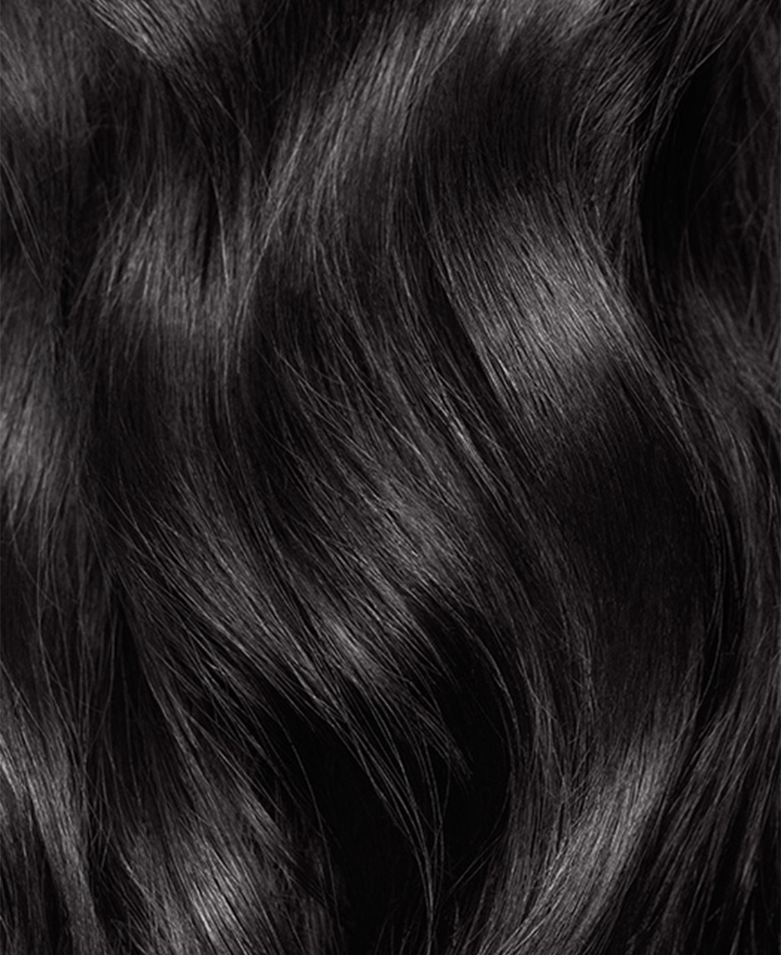 Close-up of shiny, wavy black hair texture.