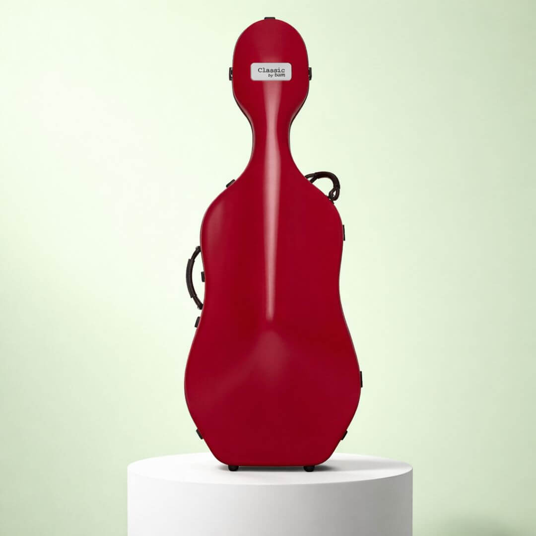 A red, hard-shell cello case with black handles stands upright on a white cylindrical pedestal.