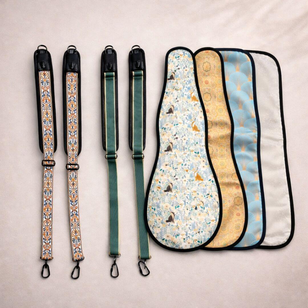 Four decorative instrument straps and four patterned ukulele sleeves are laid flat on a light surface.