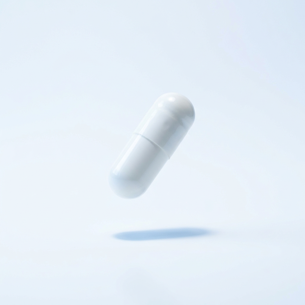 A single white pill capsule floats over a white surface, casting a soft shadow.