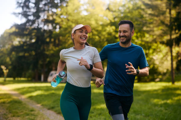 Smiling couple jogging together in a park.