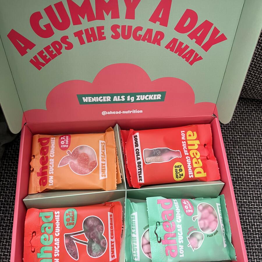 Box of assorted low sugar gummy candy packs with colorful packaging.