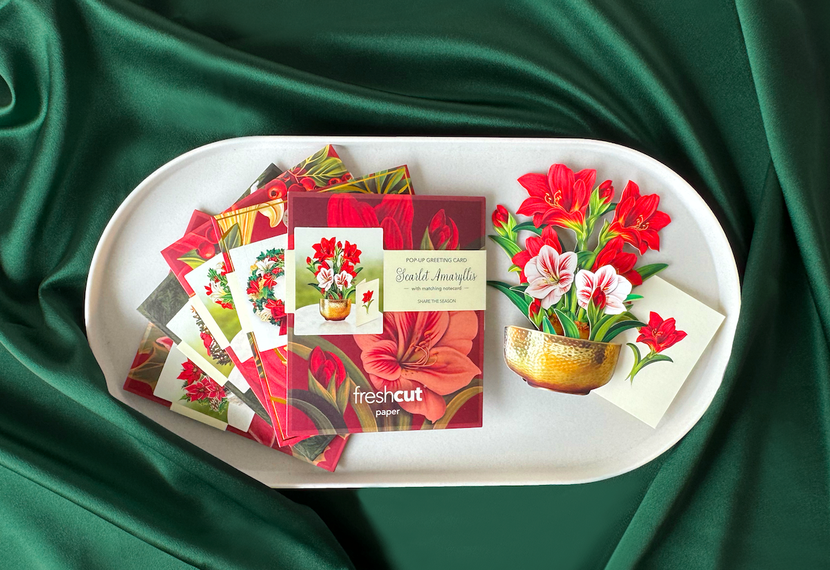 Various floral greeting cards displayed on a green fabric background.