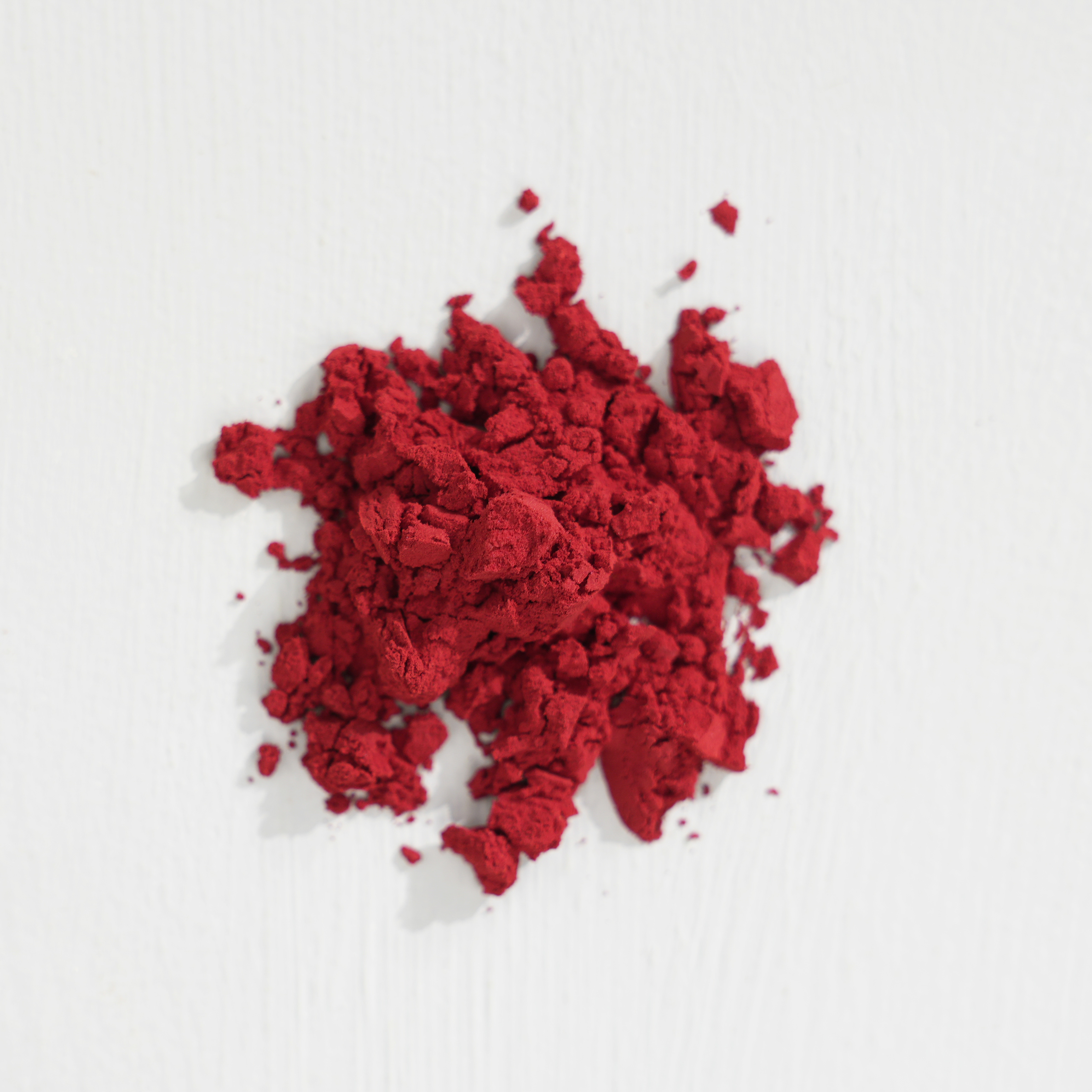 A pile of red powder on a white surface.