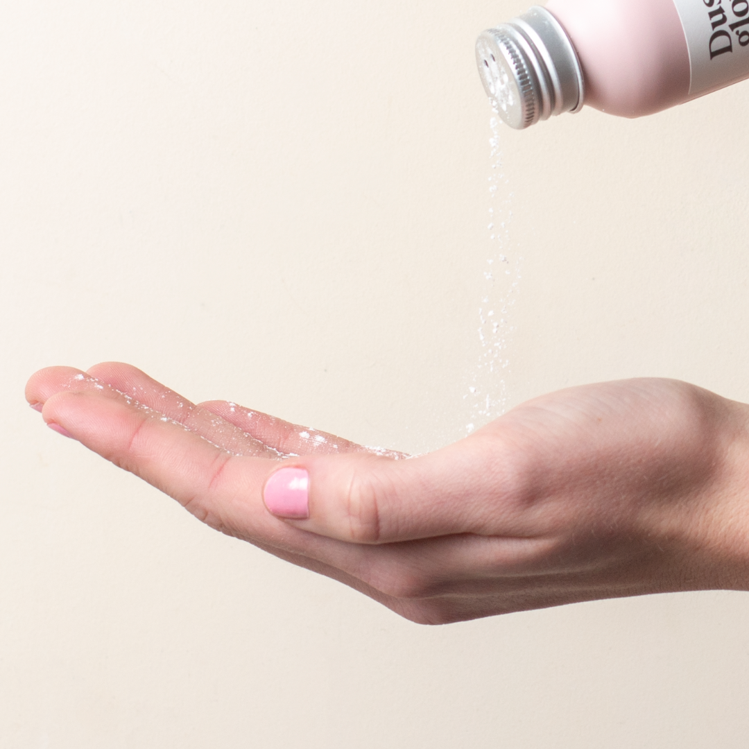 Powder being poured from a bottle onto an open hand.