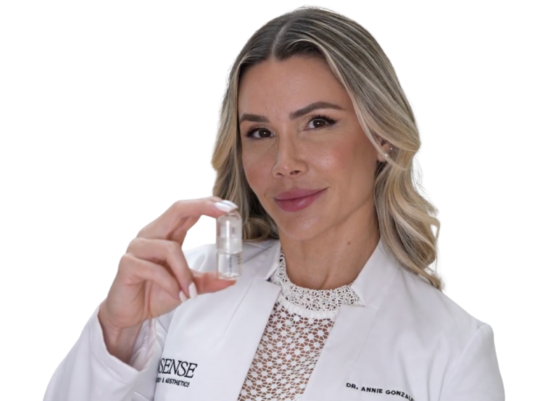 Person in lab coat holding a small bottle.