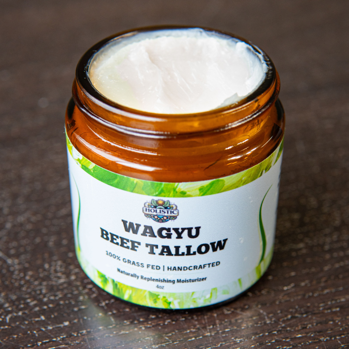 Open jar of Wagyu beef tallow moisturizer on a wooden surface.
