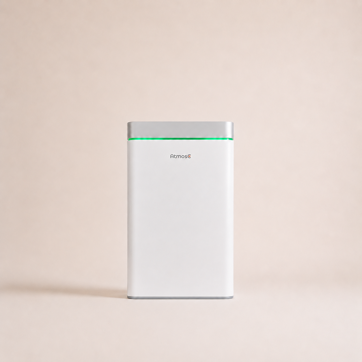 A white and silver AtmosC air purifier with a glowing green light, against a plain beige background.