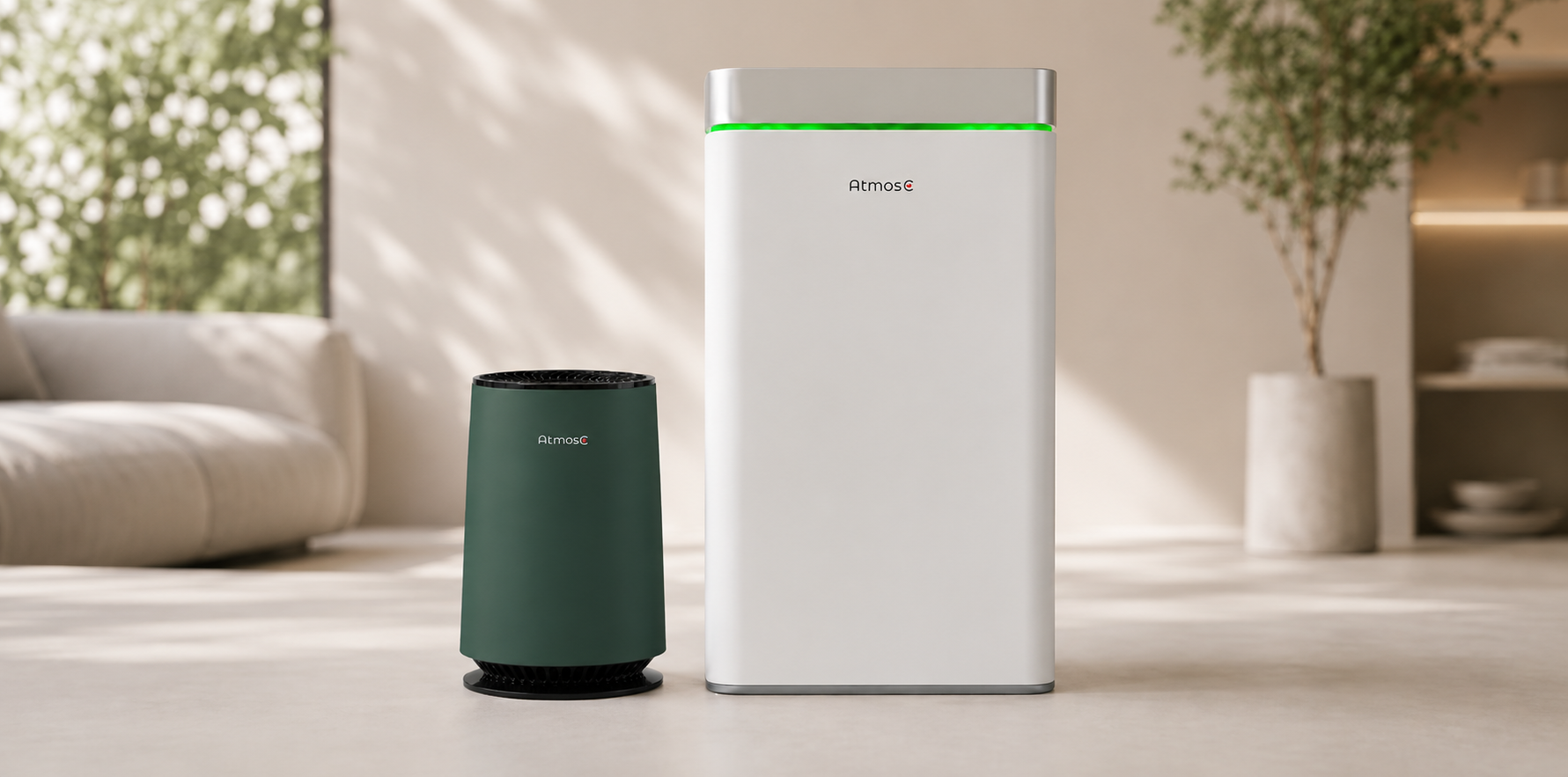 A large white AtmosC air purifier and a smaller green one sit on the floor of a room.