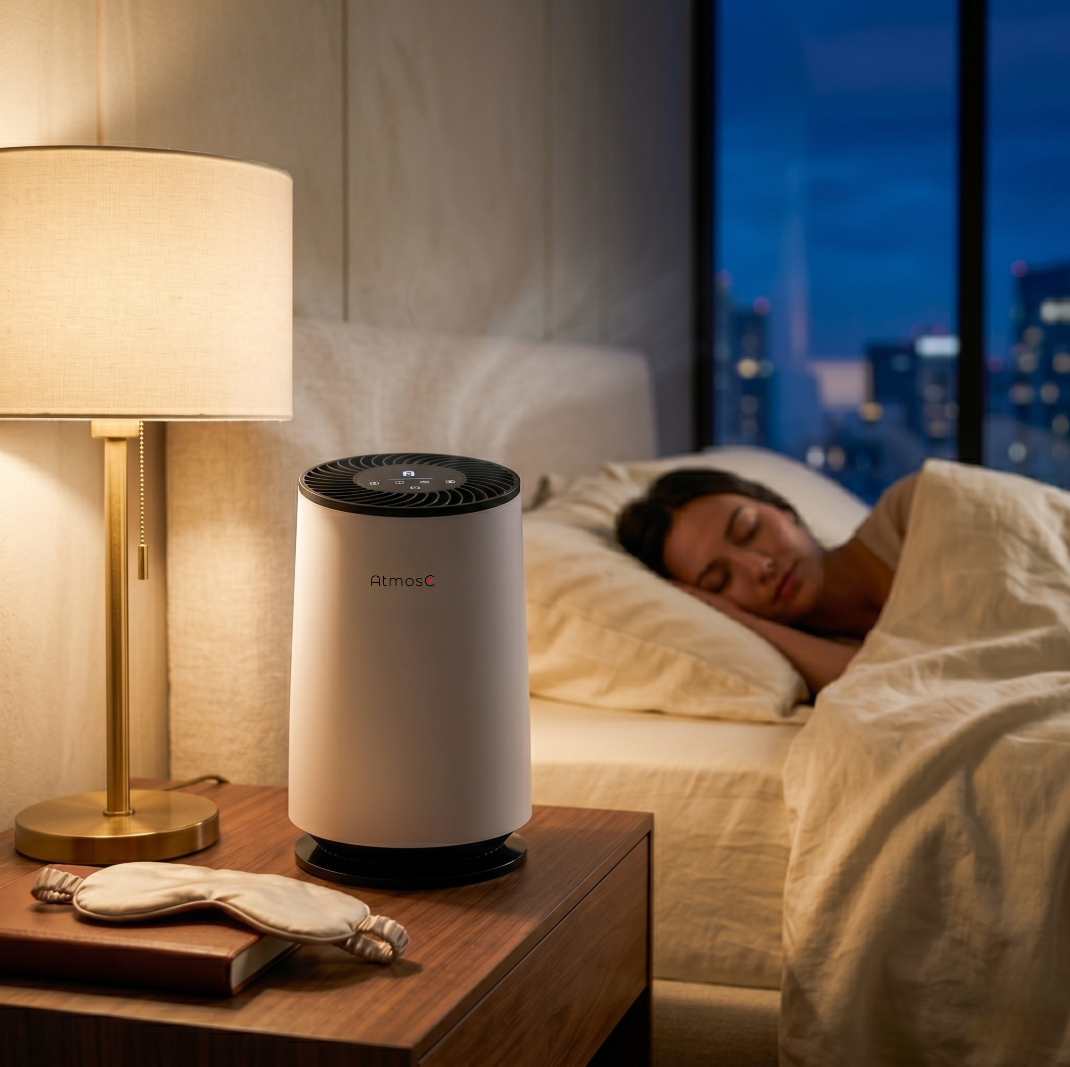 An AtmosC air purifier on a nightstand in a bedroom while a woman sleeps in the background.
