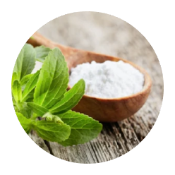 Wooden spoon with white powder and green leaves on a wooden surface.