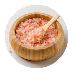 Wooden bowl filled with pink Himalayan salt and a wooden spoon.