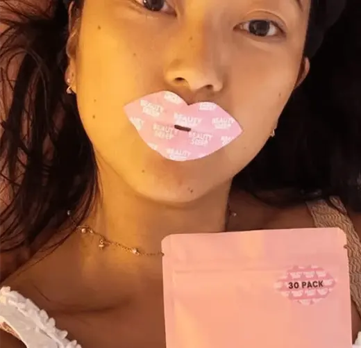 Person with lip mask and holding a pink package.