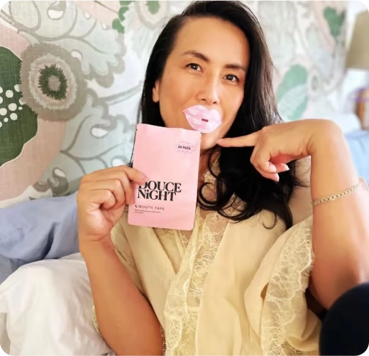 Person holding a pink package with mouth tape on lips.