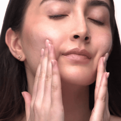 Person gently massaging their face with closed eyes.