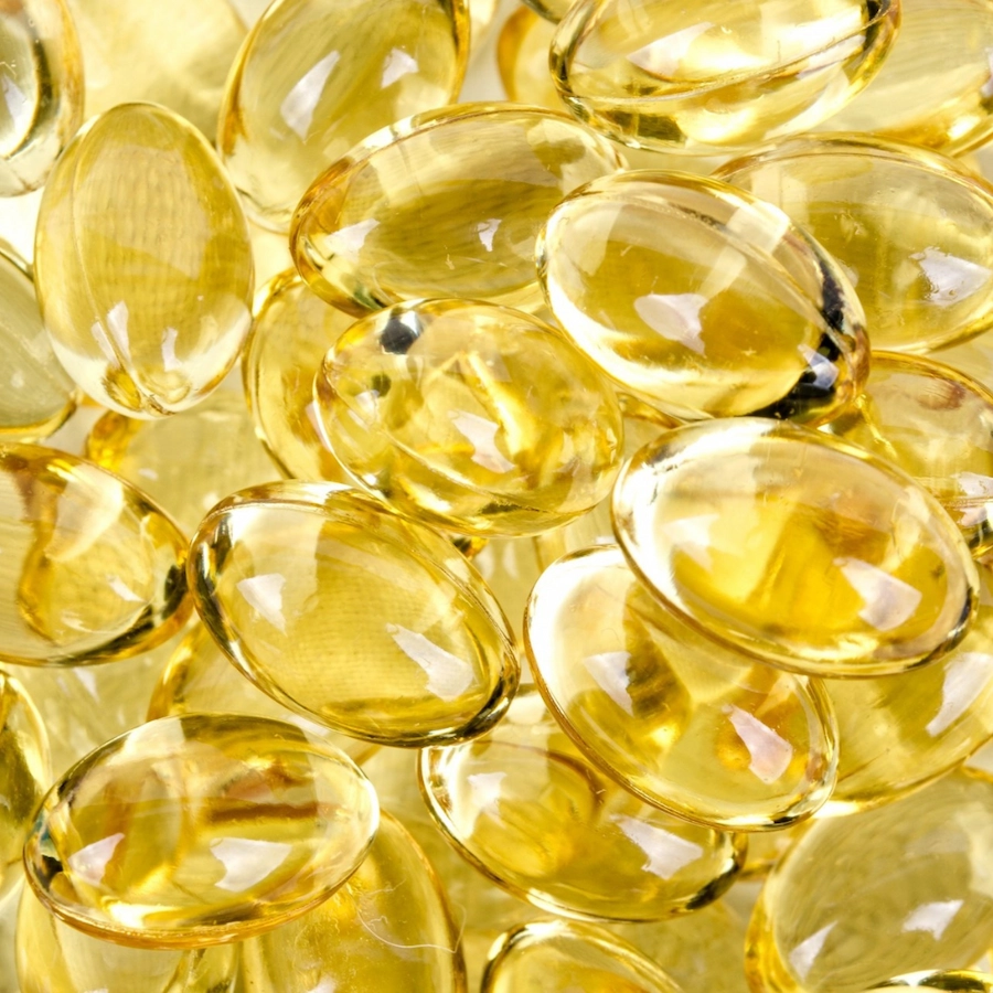 Close-up of yellow translucent capsules piled together.
