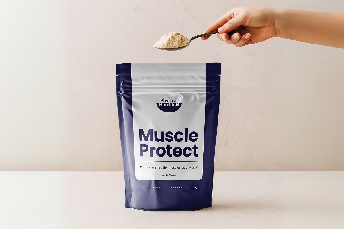 A hand holds a spoon of powder above a Muscle Protect supplement bag.