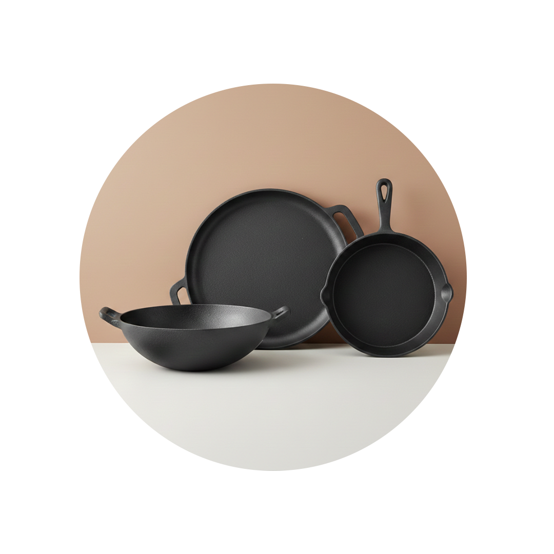 A set of three black cast iron cookware pieces, including a wok, griddle, and skillet.