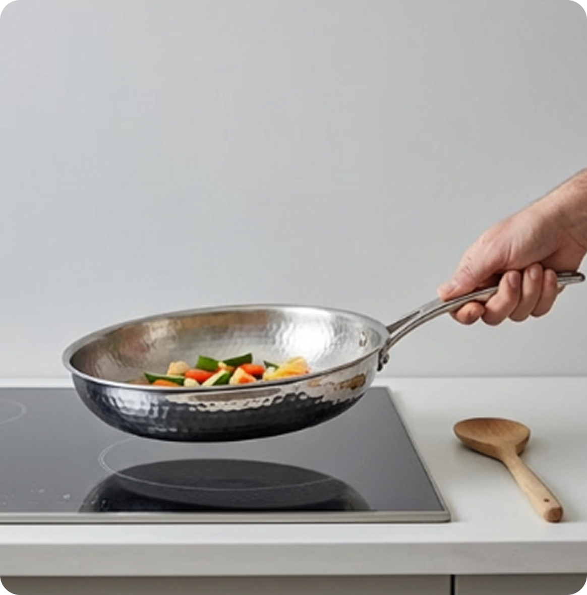 Three steaming potato pancakes being tossed in a frying pan in a kitchen.