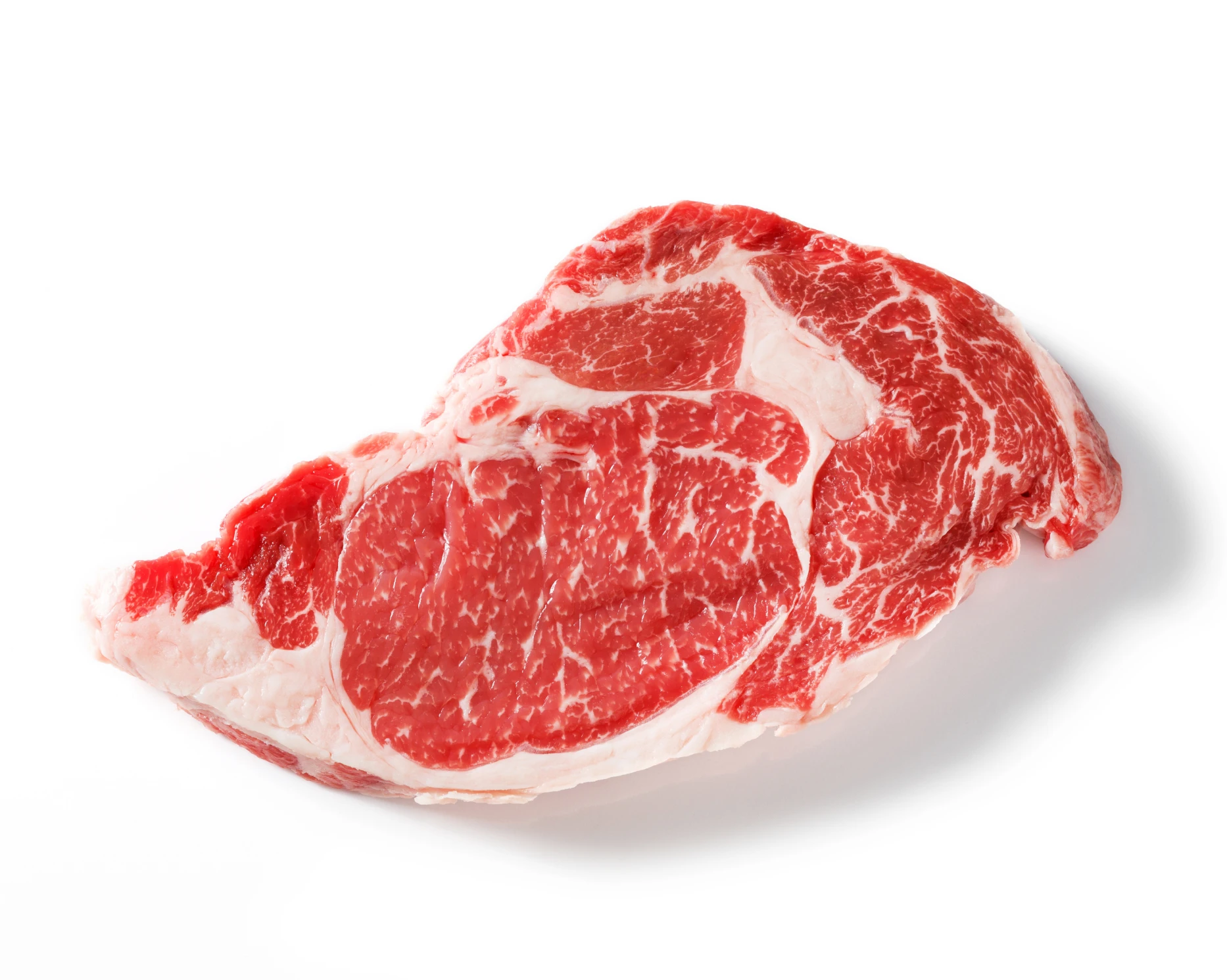 A single raw, marbled ribeye steak sitting on a plain white background.