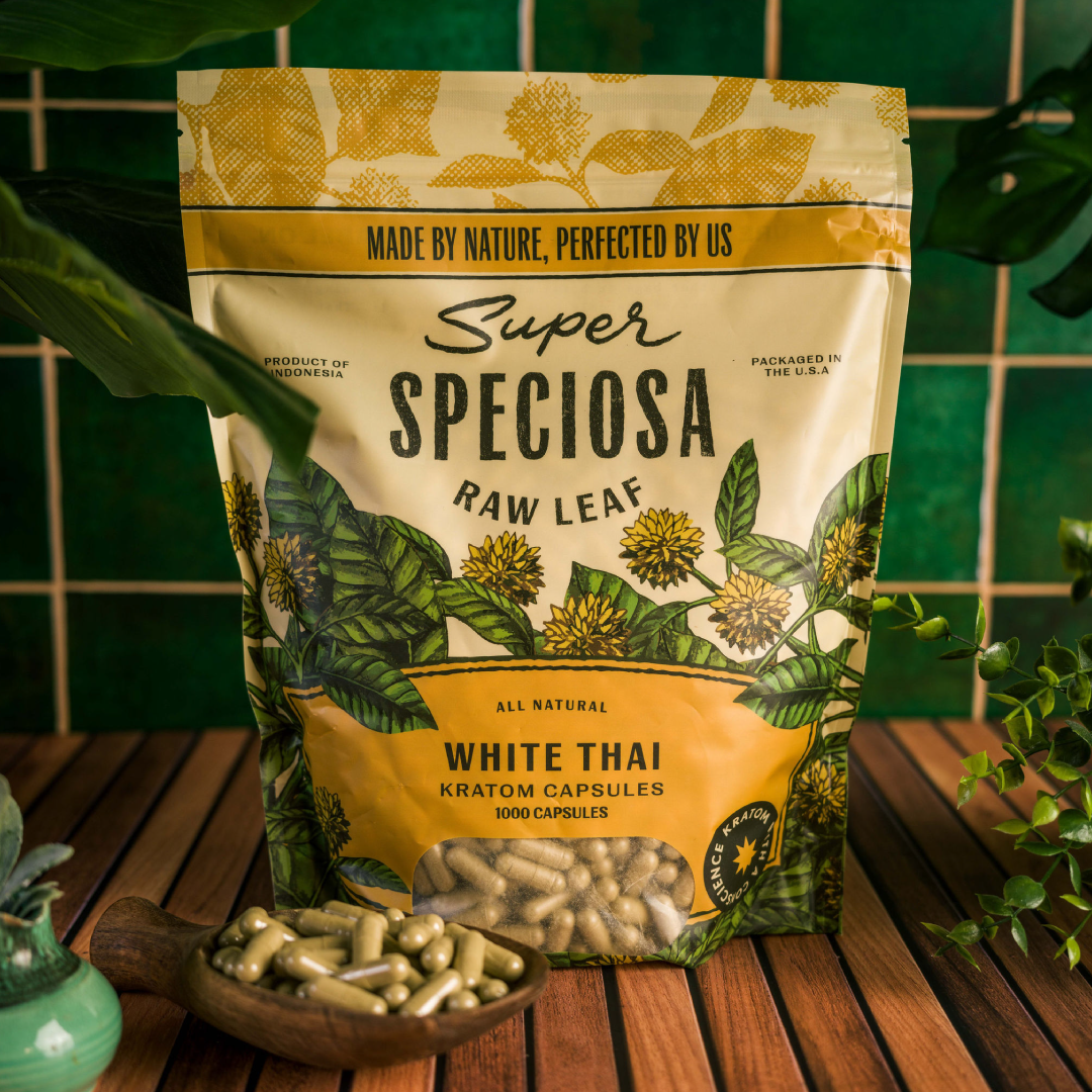 Bag of Super Speciosa White Thai Kratom capsules on a wooden table.