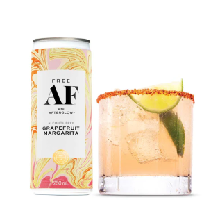Grapefruit margarita in a can beside a glass with lime garnish.