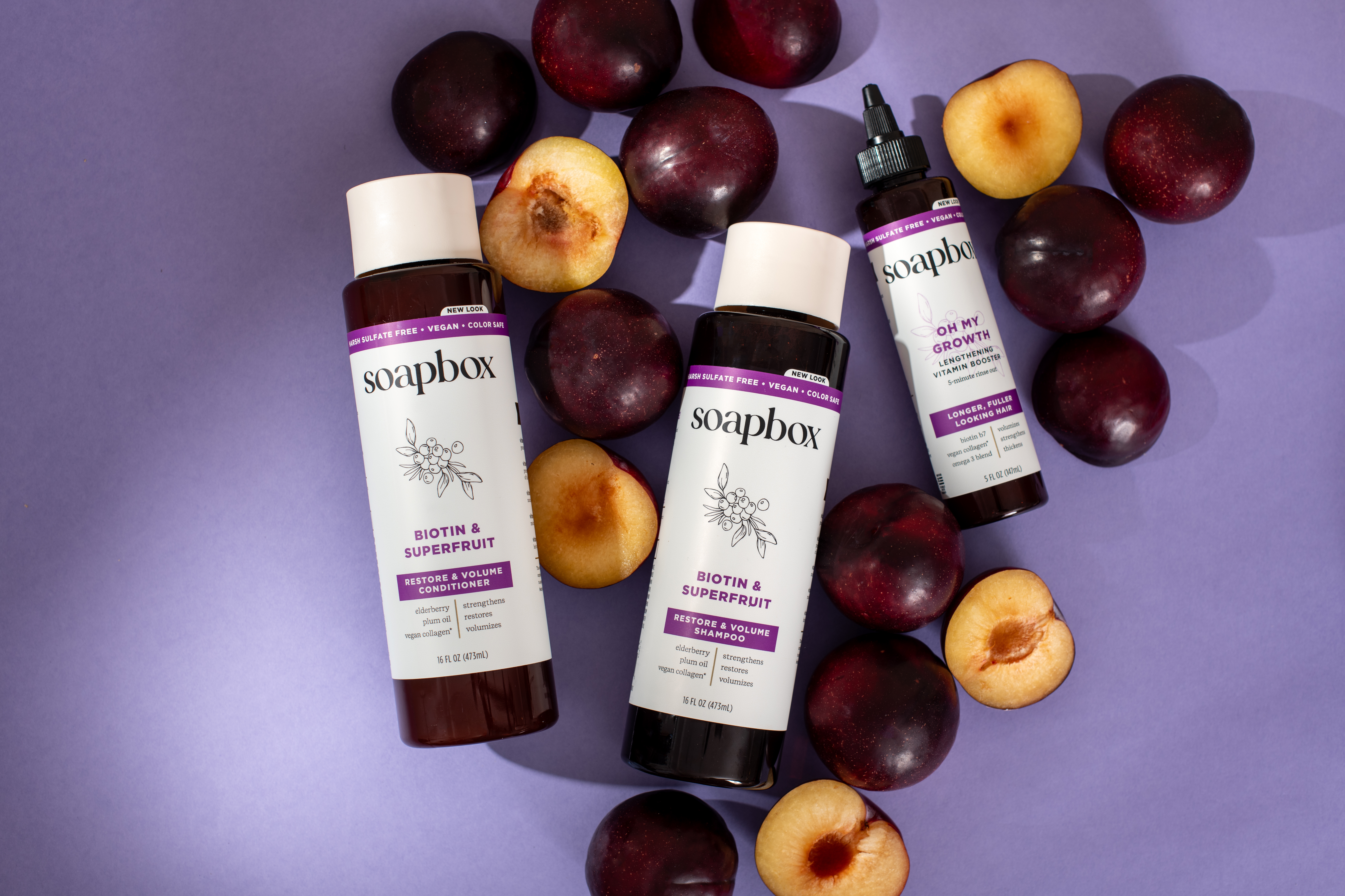 Soapbox hair products with plums and peaches on a purple background.