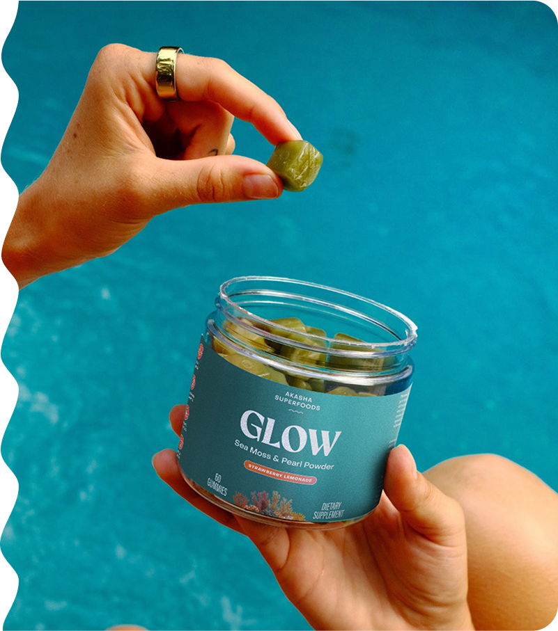 Hand holding a gummy above a jar labeled 'Glow' by a pool.