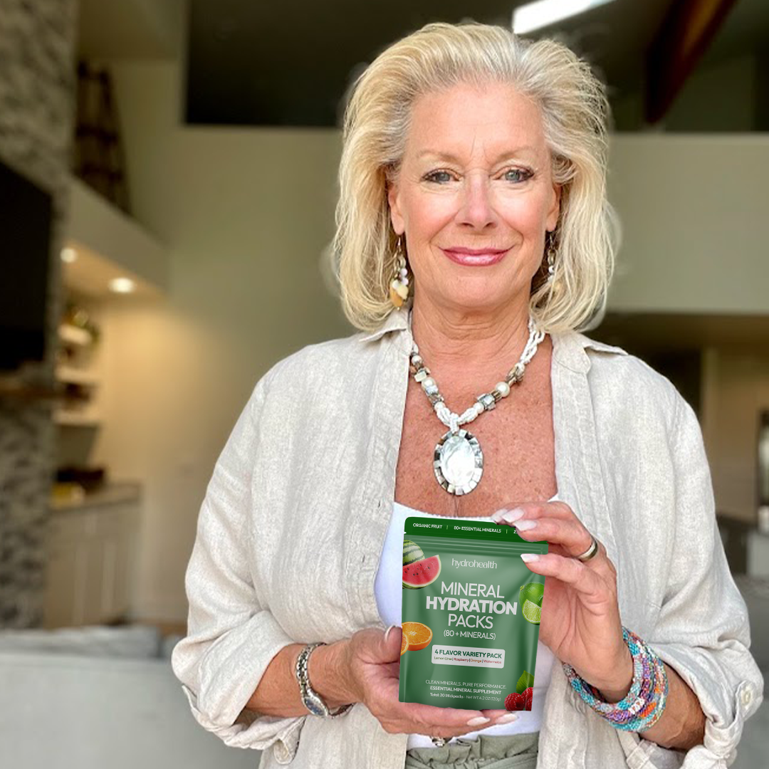 Person holding a packet of mineral hydration packs indoors.