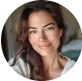 Smiling person with long brown hair in a circular frame.