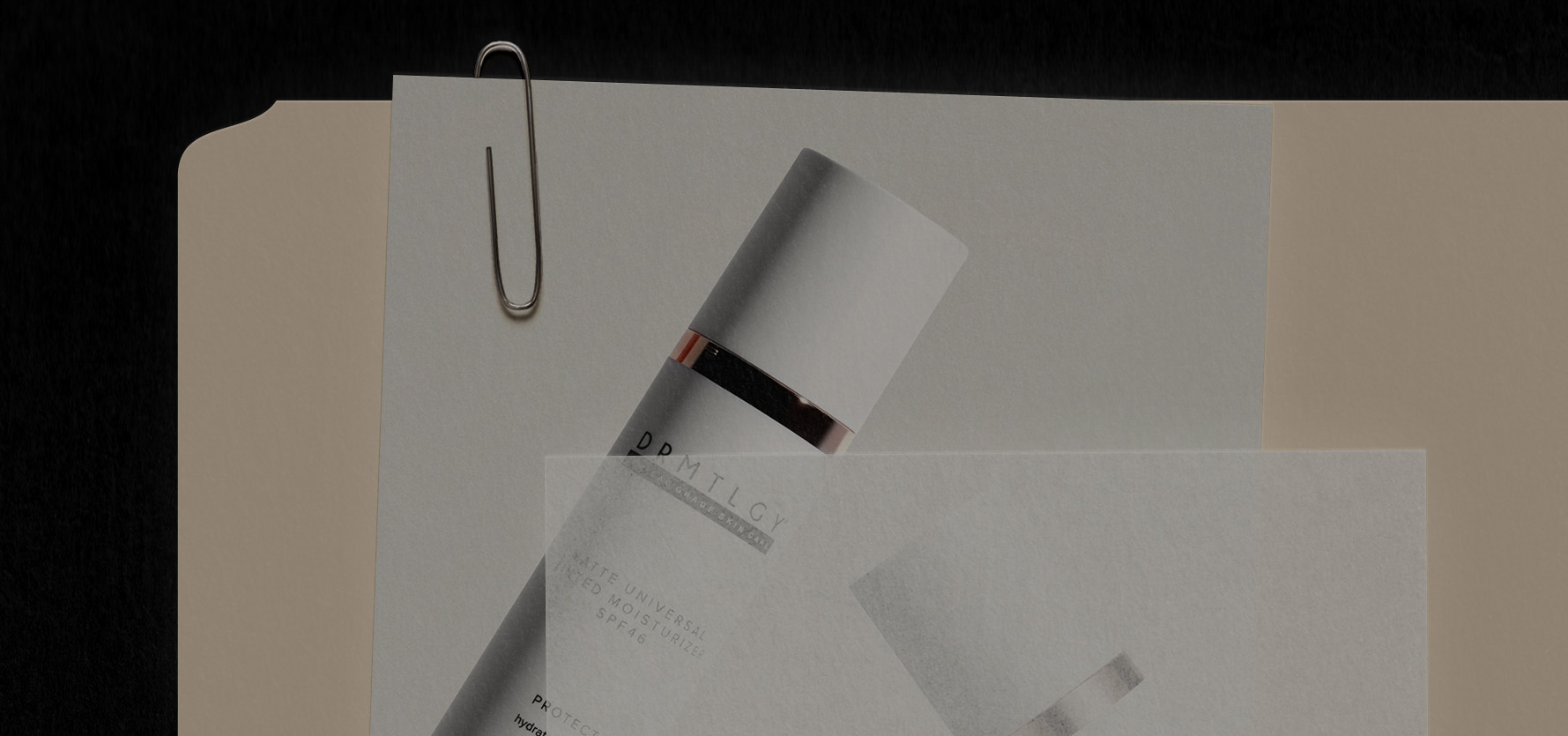Paper with a metal clip and partial view of a cosmetic product.