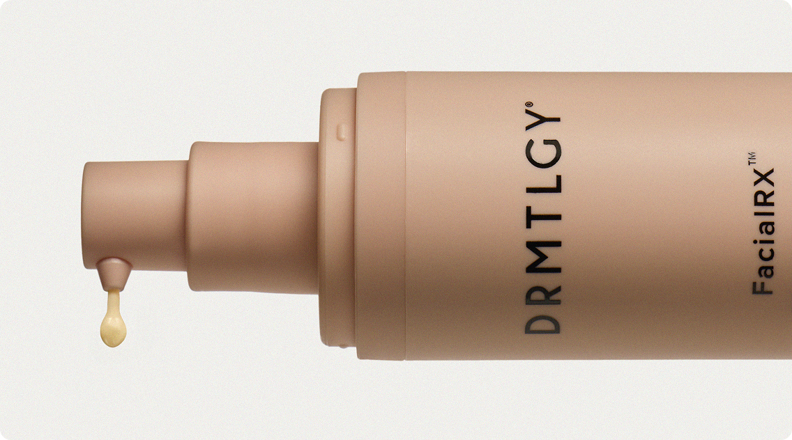 A close-up of a beige DRMTLGY cosmetic pump bottle dispensing a single drop of yellow product.