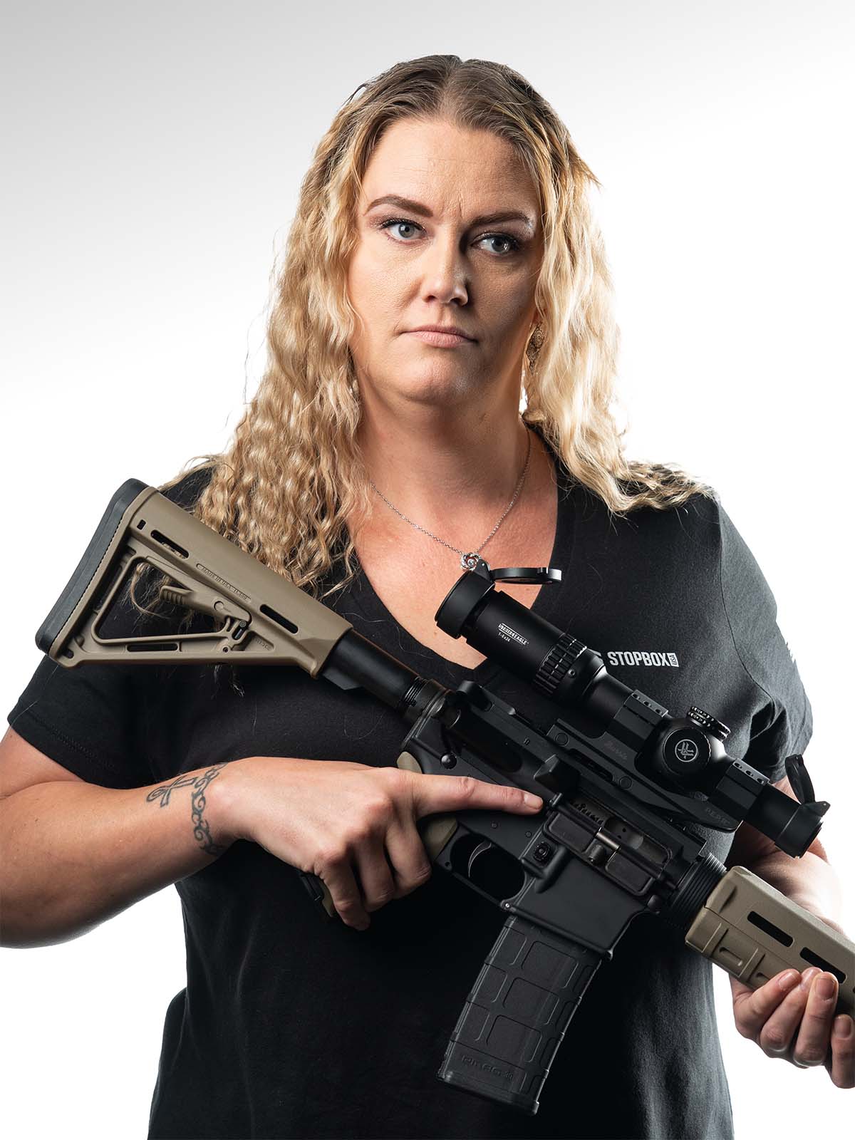 Person holding a rifle with a determined expression.