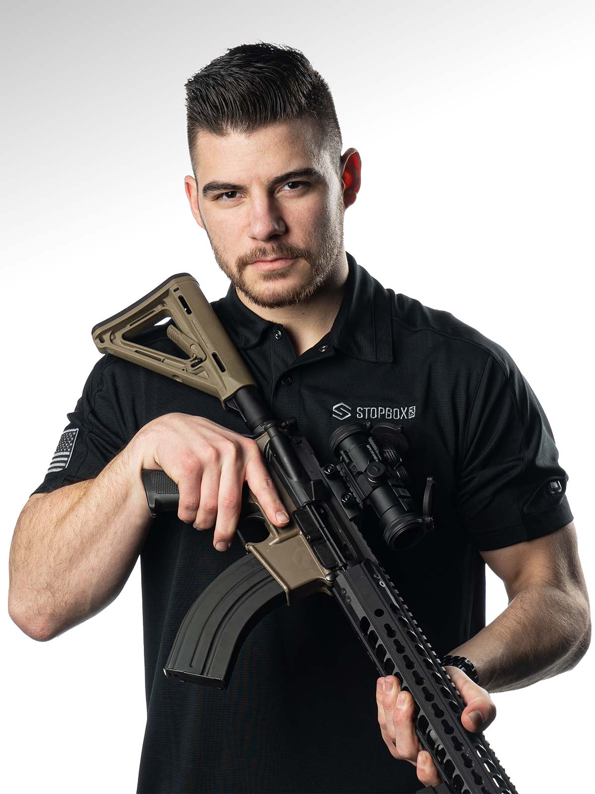 Person holding a rifle with a serious expression.