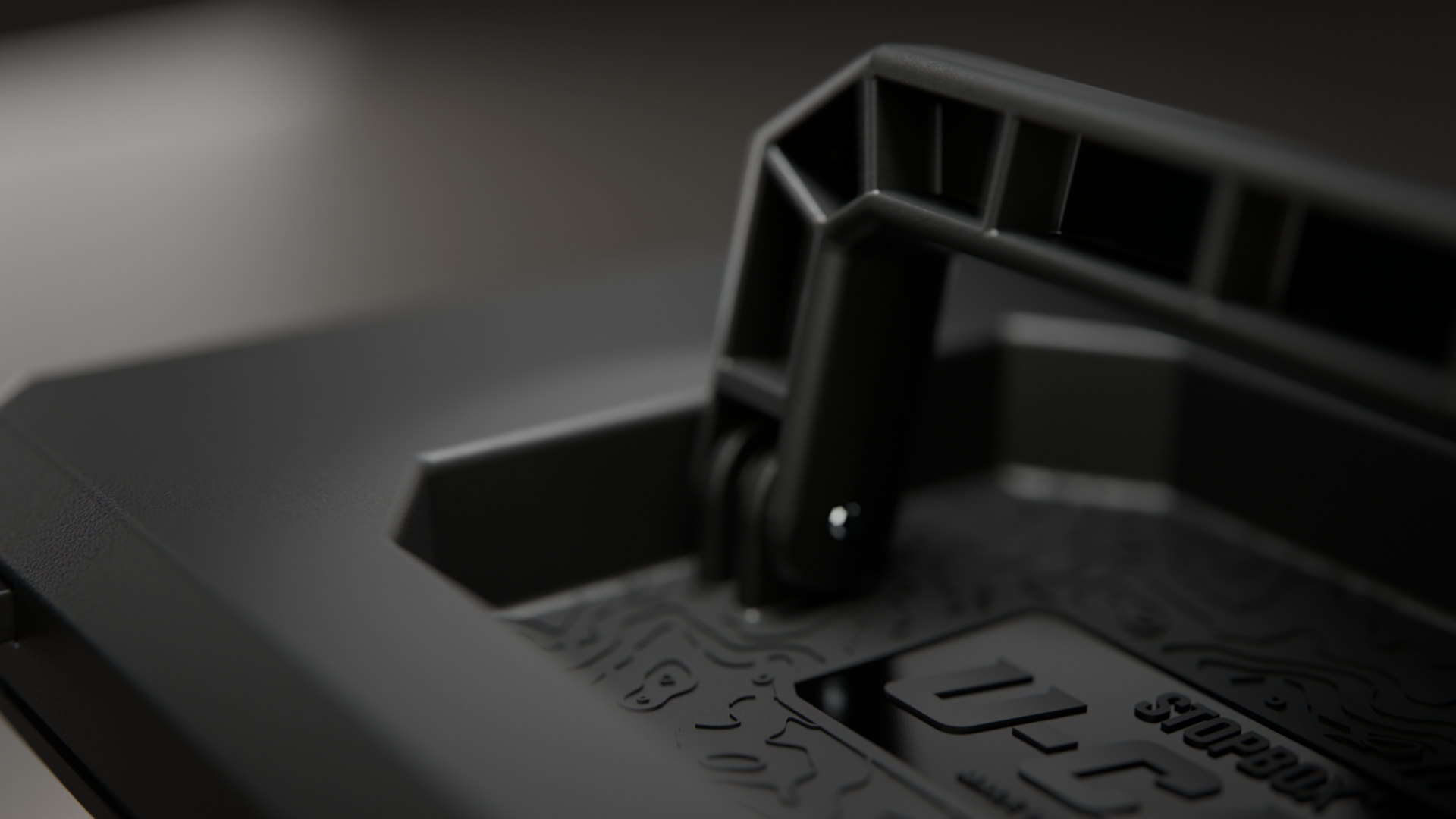 A close-up, angled shot of the handle and textured lid of a black Stopbox case.